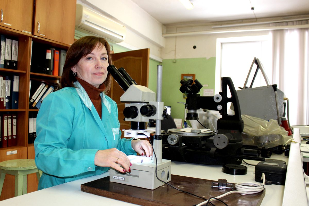 Начальник лаборатории электрических и механических испытаний О. В. Макарова контролирует дефекты с помощью стереомикроскопа