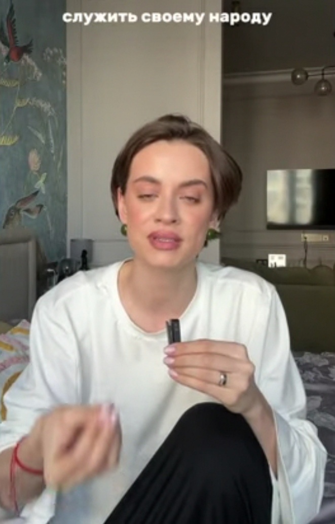 Красная ниточка на запястье, смотрите. Боится, что сглазит народ. 