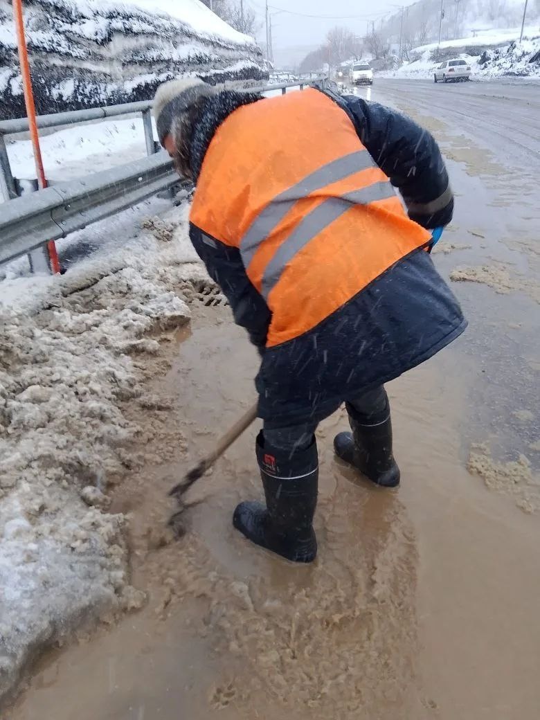    дворник расчищает ливневку