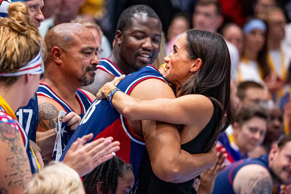 Меган Маркл обнимает члена сборной США на Играх непокоренных 2023 года. Патрик ван Катвейк/Getty