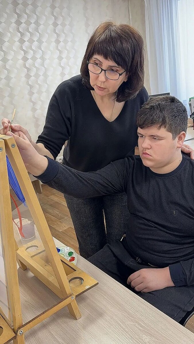 Мальчик рисует на прозрачном мольберте под руководством Заречневой Ларисы Павловны