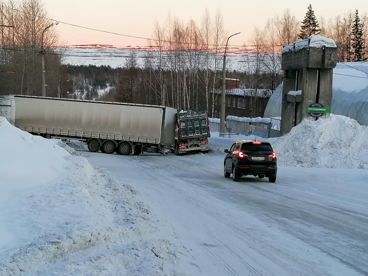Фото автора. Угадайте, что происходит? Фура с грузом съехала в кювет. Камаз вывозивший снег с улиц переоценил ситуацию. Не хотелось разворачиваться, водитель решил, что проскочит в оставшующася щель. Не проскочил. Зеркалом проехал, кузовом застрял. 