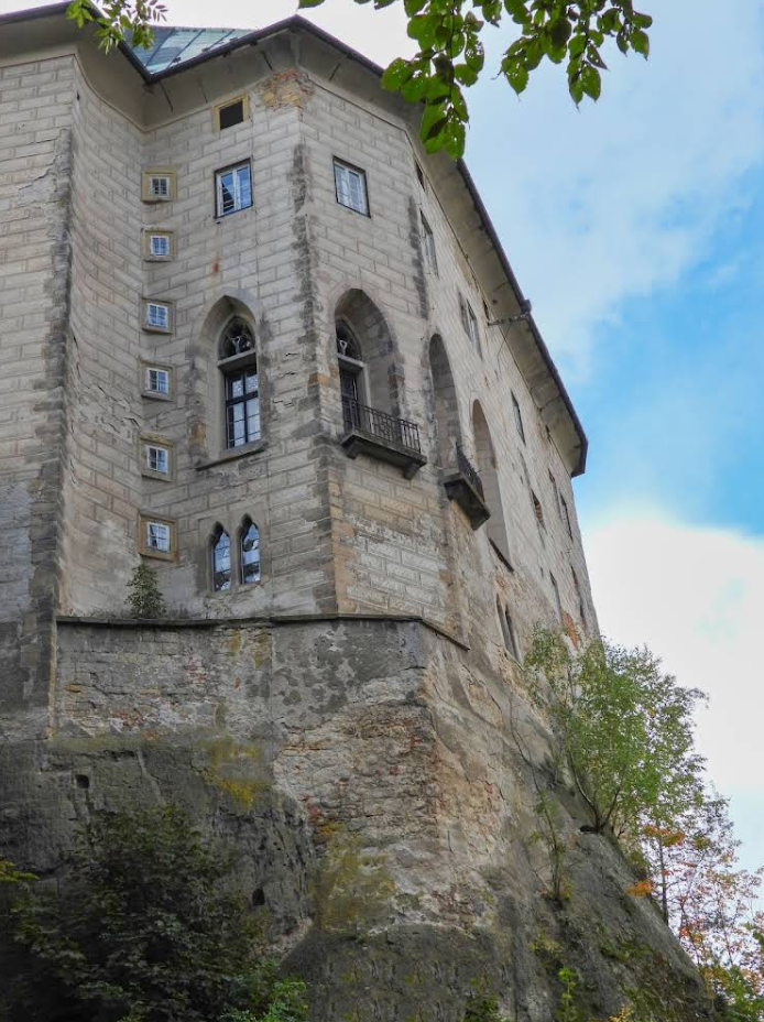 На снимке представлен северо-восточный фасад замка, буквально «вырастающий» из массивной песчаниковой скалы. Это изображение идеально иллюстрирует теорию о том, что Гоуска — не жилой дом, а оборонительный саркофаг.
