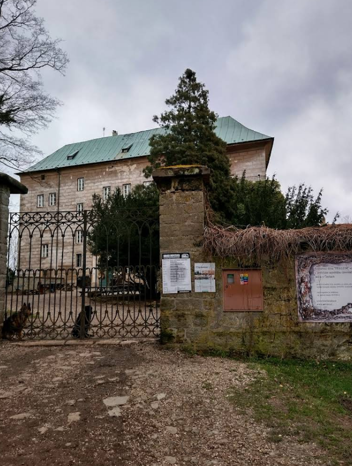 Вход в обитель тайн: Главные ворота замка Гоуска
На снимке запечатлен парадный въезд на территорию замка. Это первое, что видит путник, добравшийся сквозь густые леса Северной Богемии к «Вратам в Ад».