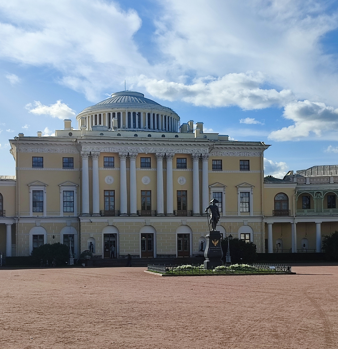 Центральная часть дворца. Дворец имеет форму подковы. Перед парадным входом установлен памятник императору Павлу I.