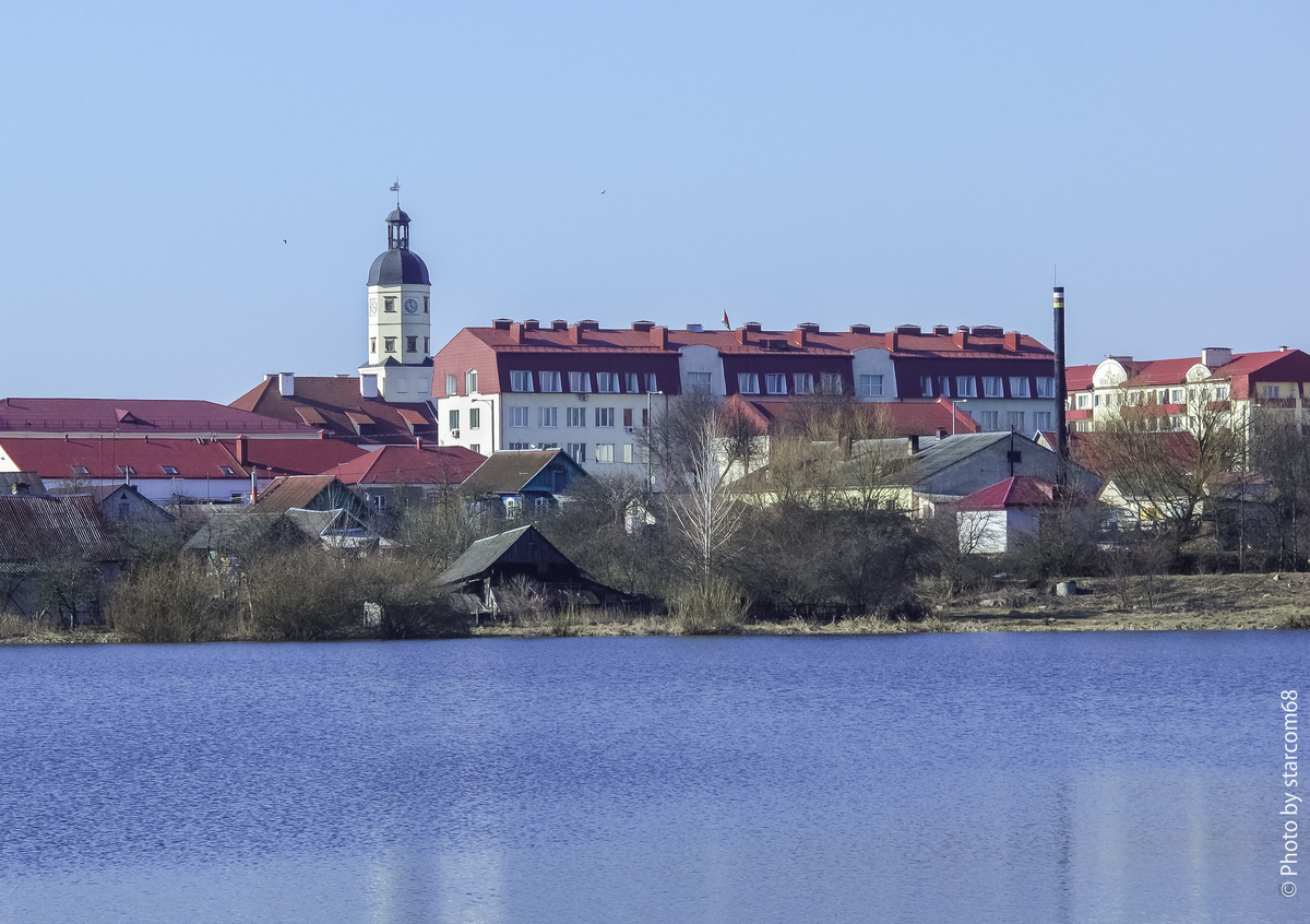 За зданием Несвижского райисполкома прячется часовая башня городской ратуши, а на переднем плане расположена знаменитая несвижская городская баня с высокой трубой кочегарки