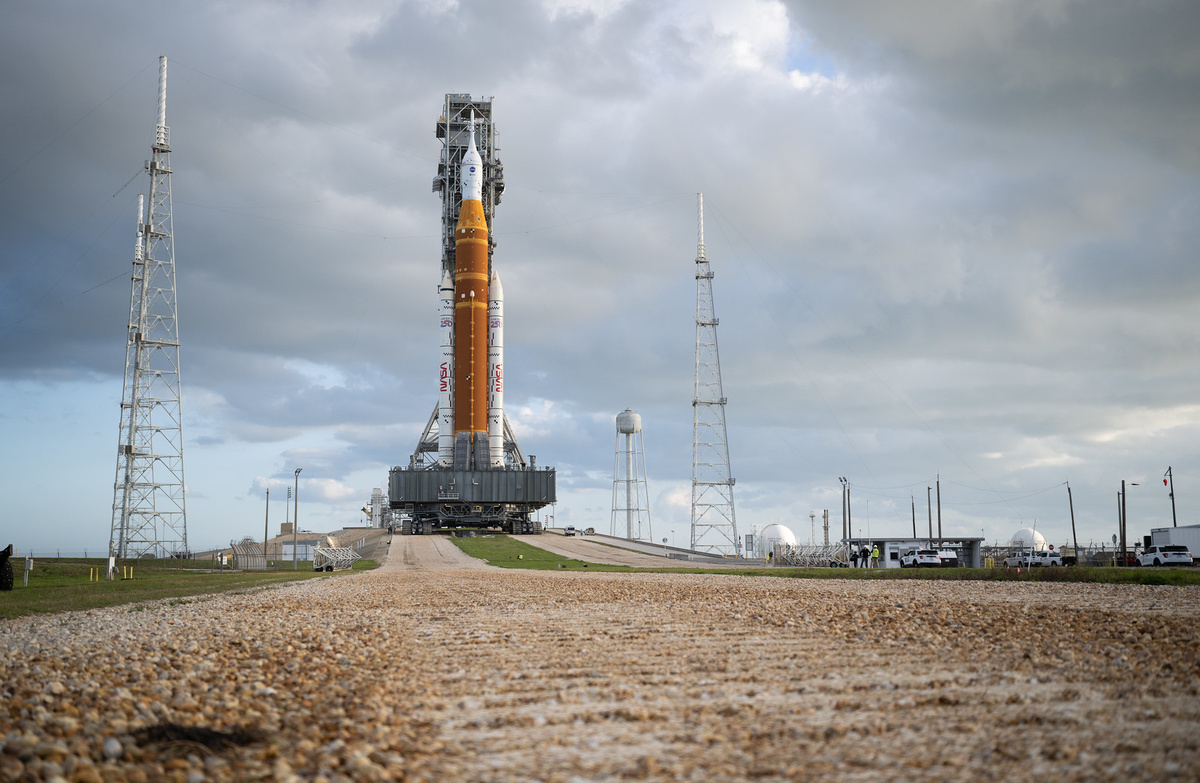 Ракета-носитель НАСА SLS и космический корабль Orion, закрепленные на мобильной пусковой установке, запечатлены во время подъема по наклонной плоскости на стартовой площадке 39B в пятницу, 20 марта 2026 года, в Космическом центре имени Кеннеди НАСА во Флориде.

