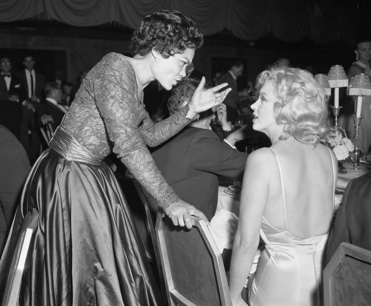 Певица и актриса Эрта Китт беседует с Мэрилин Монро на благотворительном ужине в поддержку фонда "Milk Fund". 13.06.1957. Таким образом Монро 