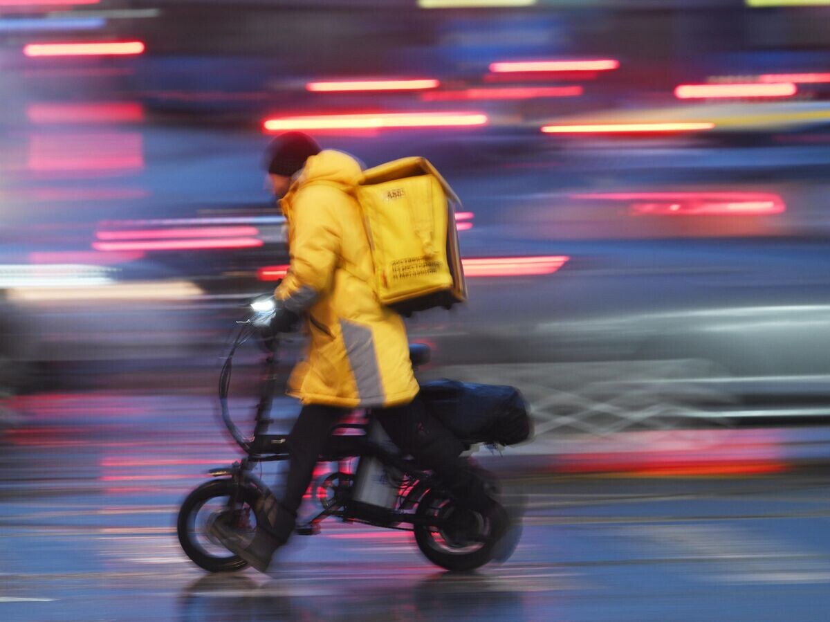    Курьер службы доставки сервиса "Яндекс. Еда" под дождем в Москве | © РИА Новости / Максим Блинов