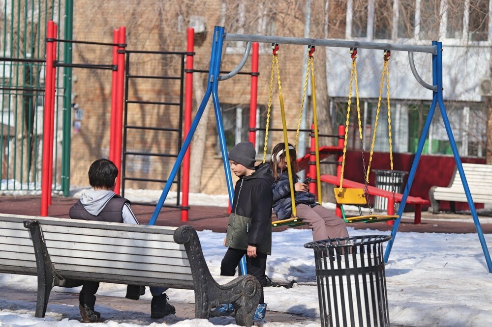 На детской площадке на той же улице.