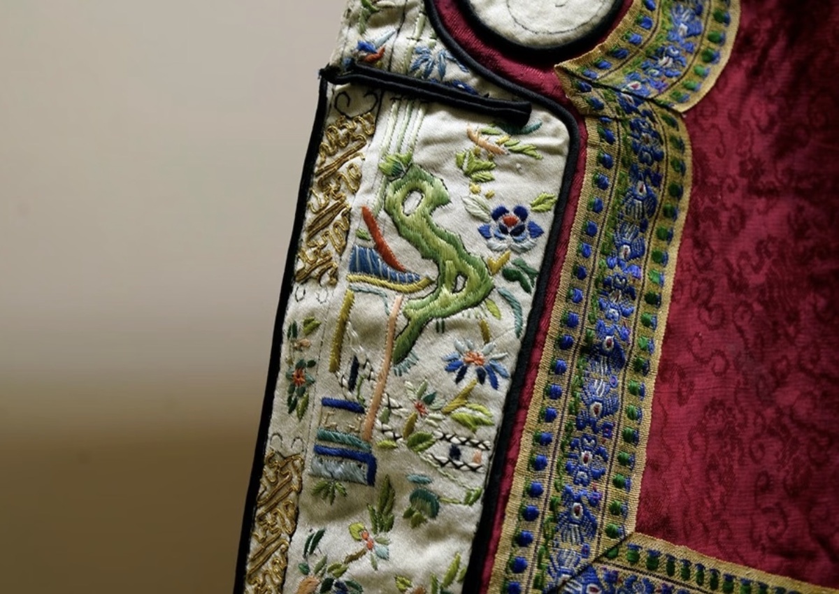 Название экспоната в оригинале: 清代镶花绦八吉祥红洋绉女夹袄. Подробное описание ниже