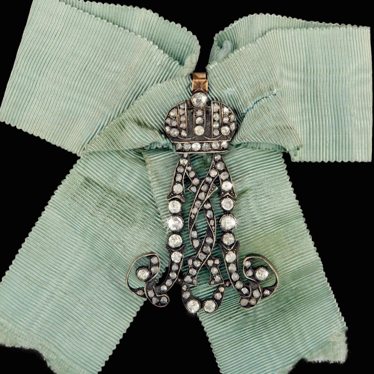 Фрейлинский знак-шифр с вензелем императрицы Марии Александровны на голубой ленте
1860-1864 гг. Частная работа. Мастерская Ивана Бека. Клейма: на петле для крепления к ленте именное «ИБ», пробирные «56» и «герб Санкт-Петербурга». Золото, серебро, бриллианты, алмазы огранки «роза». Размер 42,2×66,7 мм. Вес 27,11 г (с лентой), источник: сайт аукциона «ЗнакЪ»