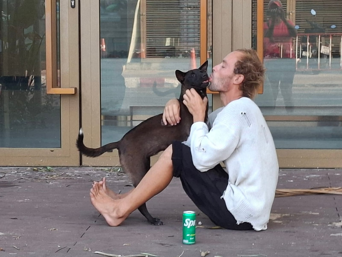 На фото поит собаку газировкой изо рта. 