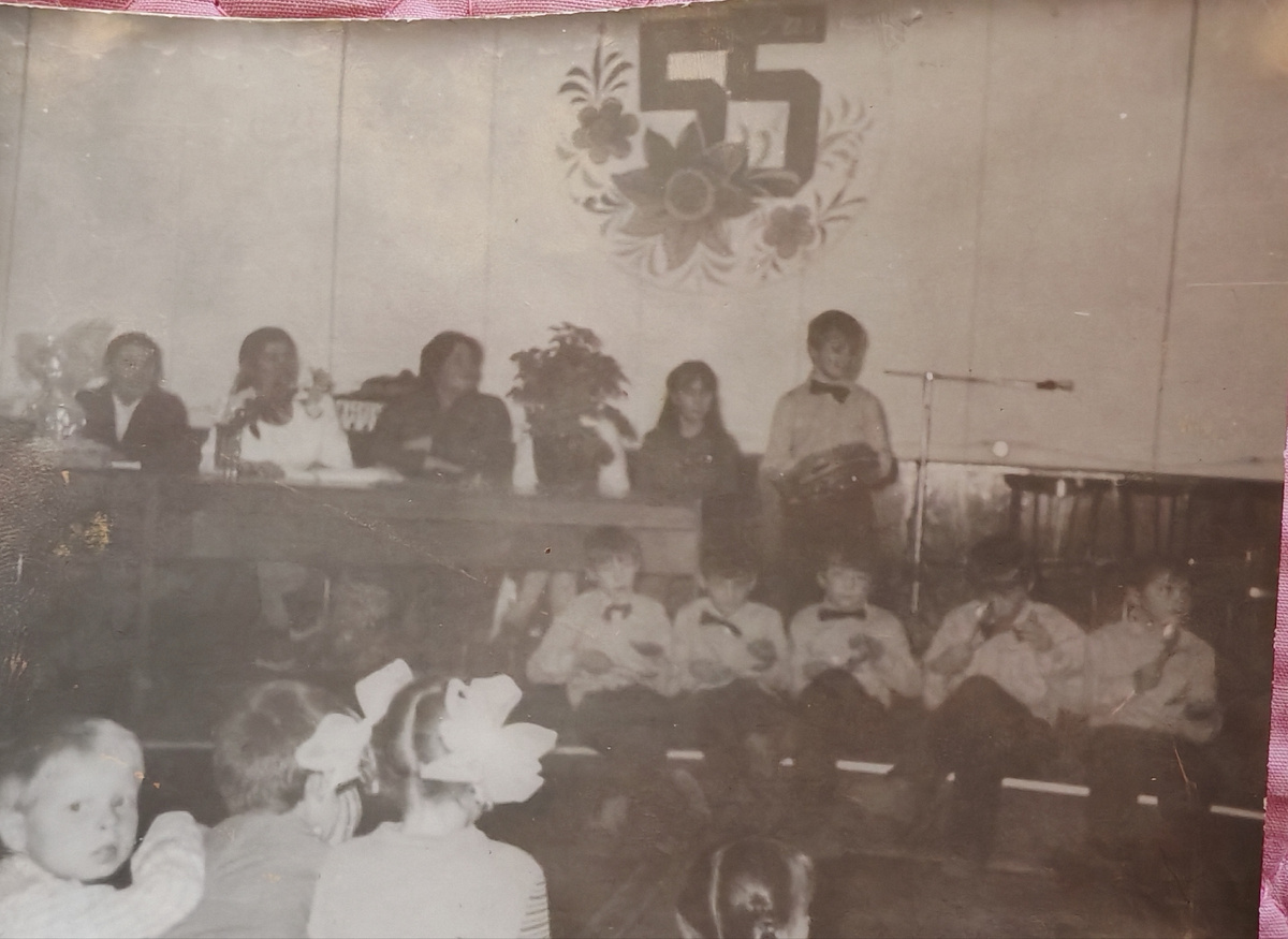 Вон я, юная комсомолка в президиуме. Рядом с пацаном с бубном.) А Полина Петровна скромно сидит слева, у края .       