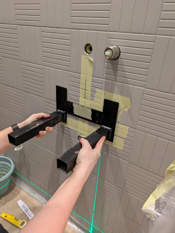 Монтажная ситуация: в текущей конфигурации правое крепёжное ухо кронштейна попадает непосредственно в зону прохождения трубы в стене, что делает невозможным крепление