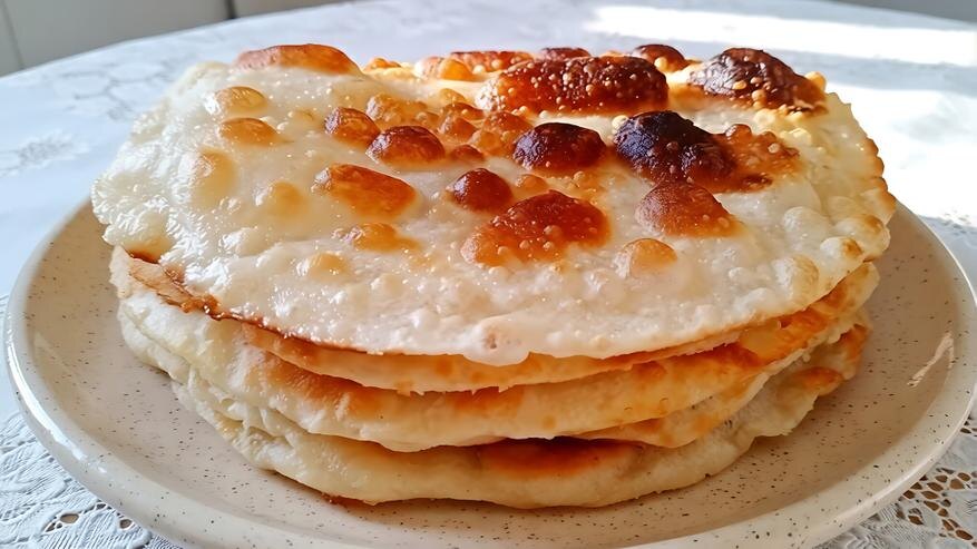 Вид готового блюда. Именно заваривание муки делает тесто настолько герметичным, что оно раздувается на сковороде, сохраняя мягкость внутри. Фото автора.