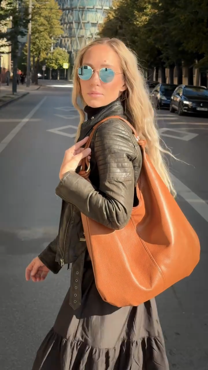 Сумка-хобо лето 2026 — мягкая замша или кожа, провисает на плече, коньячный или тёмно-бежевый