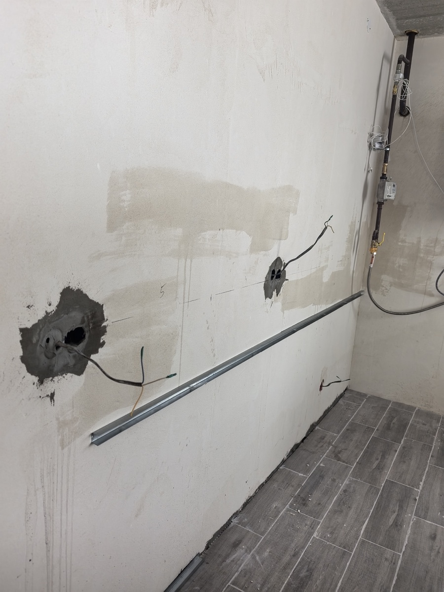 Подготовленная стена с установленными подрозетниками и металлическим профилем на уровне будущей столешницы