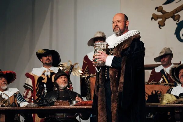 Театральное представление: Бывший бургомистр Георг Нуш опустошает кубок вина.