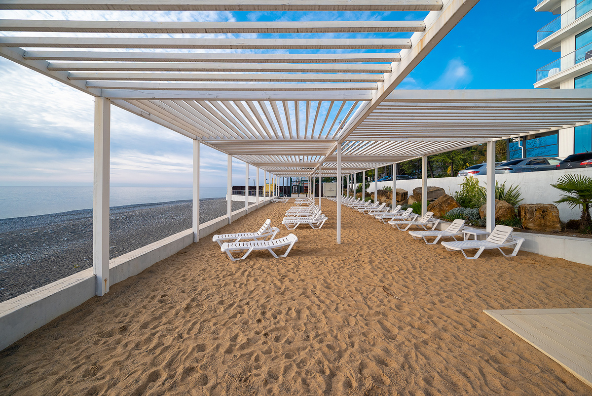 Искуственный песочный пляж на берегу моря.