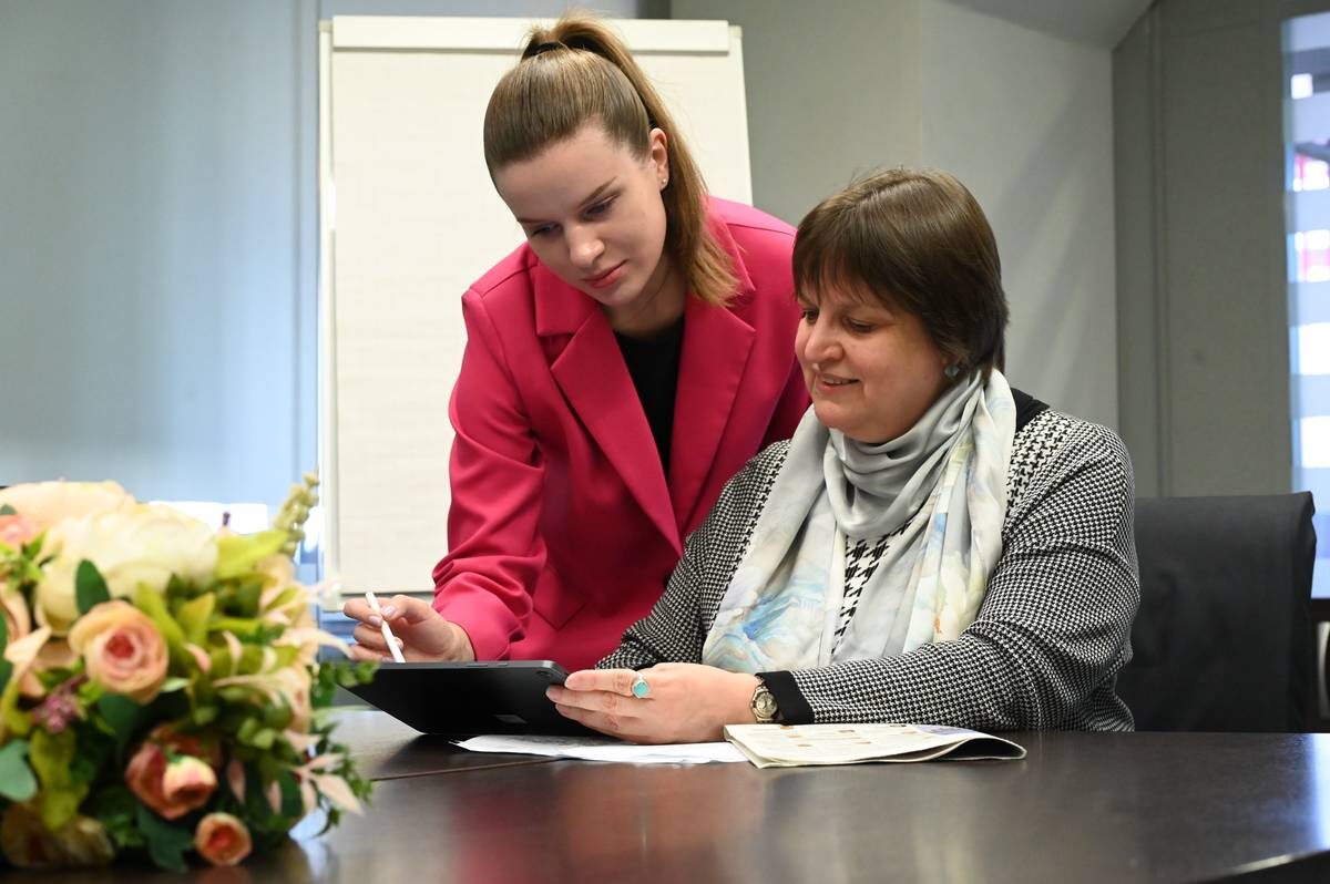    Карина Щемелинина объясняет коллеге Вере Ключниковой, как работать с ИИ / Фото: Мария Хапцова / Вечерняя Москва