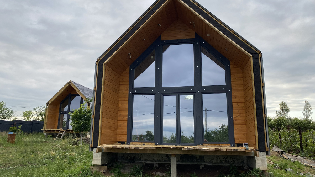 Строительство идет сразу на двух объектах. Справа — фасад с панорамным остеклением и частичной отделкой