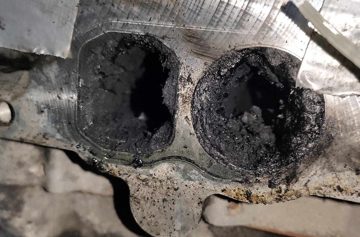 Закоксованный впуск на двигателе OM642: справа — впускной канал с вихревой заслонкой, заблокированной нагаром, образующимся из смеси масляного тумана и сажи из системы EGR