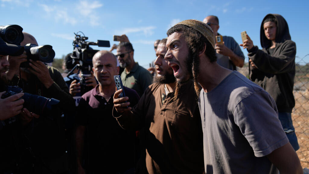 Израильские поселенцы во время их попытки помешать сбору урожая в оливковых рощах палестинскими фермерами в городе Сильвад на Западном берегу 29 октября 2025 года. © Associated Press / архив