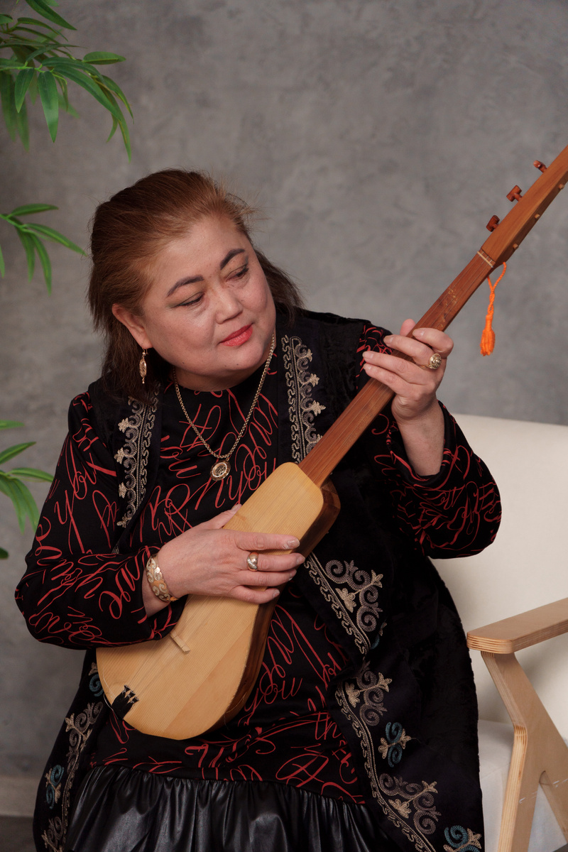 Астрагуль Абсадыкова играет на комузе