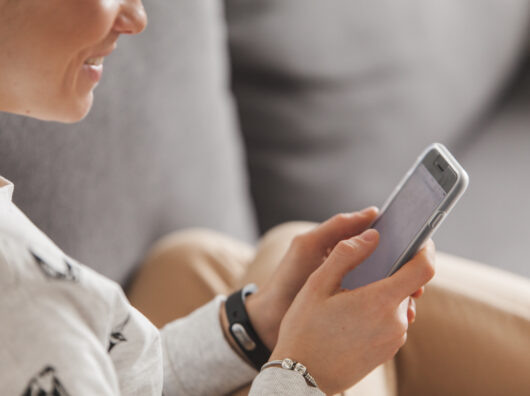    Женщина смотрит на смартфон //Фото Freepik