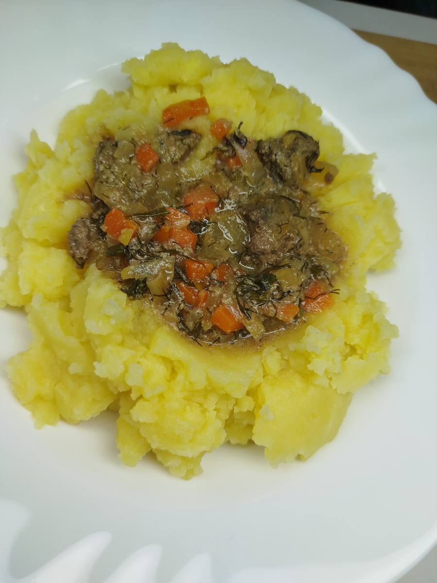 Промываем печень, удаляем протоки и плёнку. Нарезаем на кусочки. Нарезаем лук мелко. На раскалённую сковородку  добавим сливочное масло, добавляем лук томим лук до прозрачности. Затем добавляем печень и присыпаем мукой. Перемешиваем. Обжариваем 10-15 минут. Часто помешивая. Добавляем воду и убавляем огонь, тушим. Спустя 10 минут добавляем соль, перец, зелень. Перемешать и тушить ещё 5 минут.