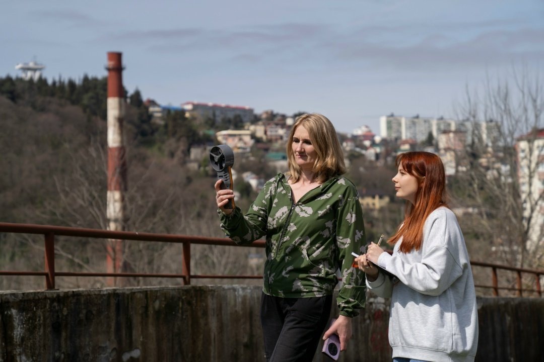    Исследовательницы СНЦ РАН на фоне отдаленной городской застройки
