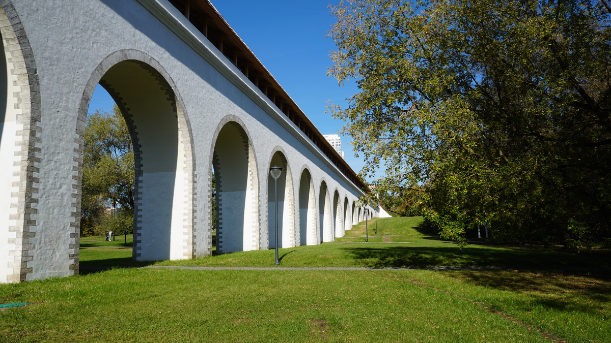История под аркой: Ростокинский акведук. 🏛️✨ Взгляните на наследие прошлого сквозь монументальную белую арку легендарного Ростокинского акведука. Ритм каменной кладки, уходящая вдаль дорожка и пышная зелень парка Яуза создают завораживающий туннель времени. Идеальное место для атмосферных прогулок и фотосессий. 🌿📸 Ощутите мощь истории в черте современного мегаполиса!