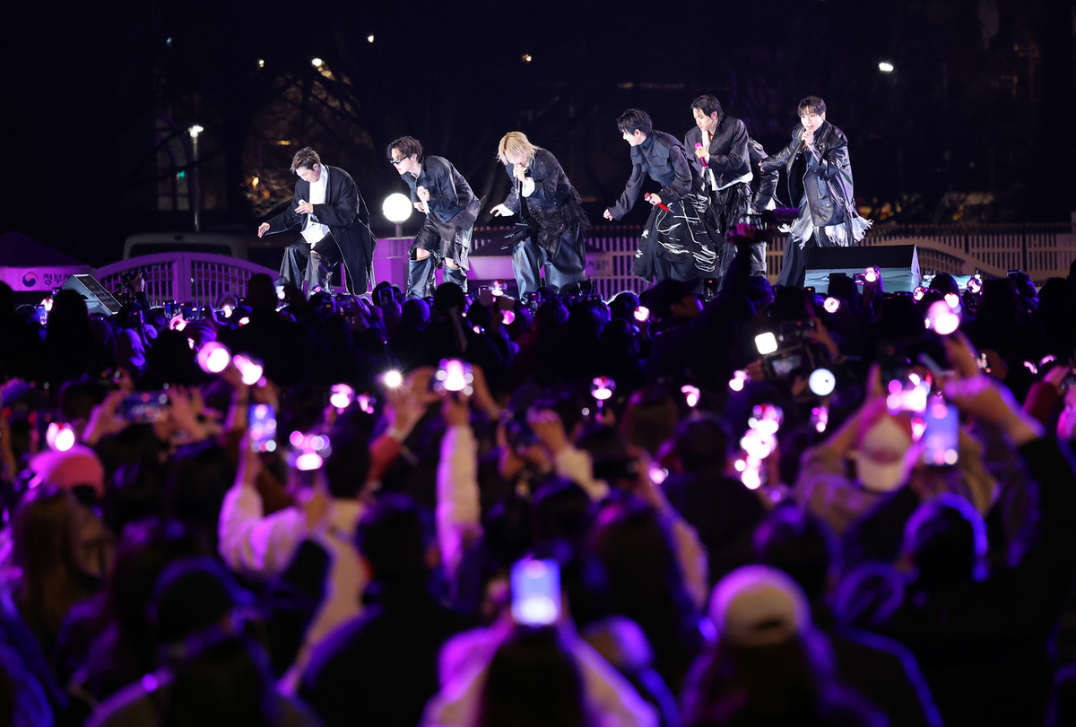 Фанаты записывают концерт BTS, посвященный возвращению группы, который состоялся 21 марта в Кванхвамуне, Сеул. (Yonhap)