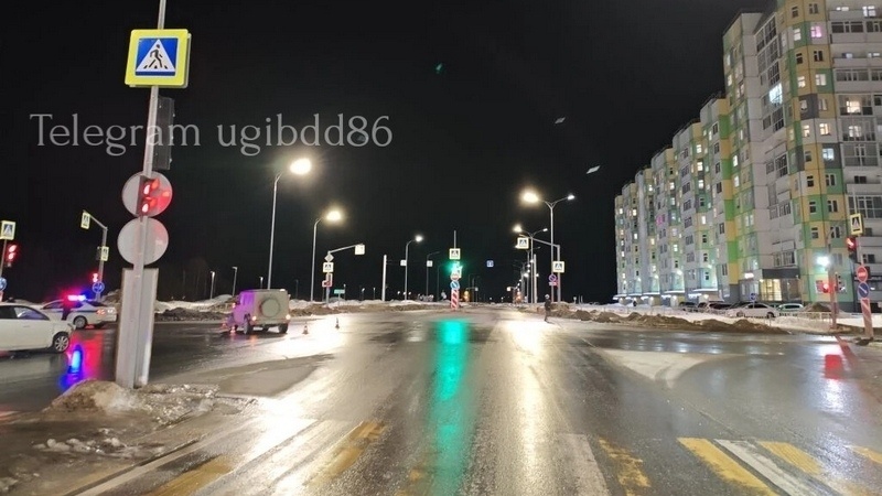    Ночное перекрестье Нижневартовска: Mercedes и Changan возле освещенных домов, мокрый светло‑зелёный отполированный асфальт Главный редактор