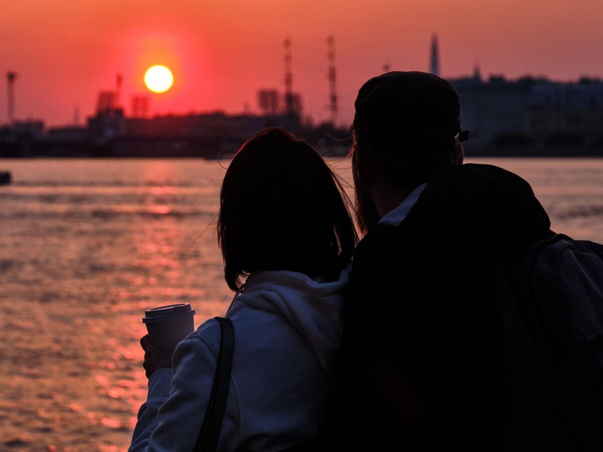    Пара встречает закат с видом на стрелку Васильевского острова с Дворцовой набережной в Санкт-Петербурге | © РИА Новости / Алексей Даничев
