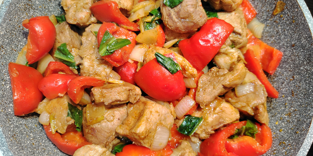 Свинина, тушенная со сладким перцем, репчатым луком и черемшой на сковороде