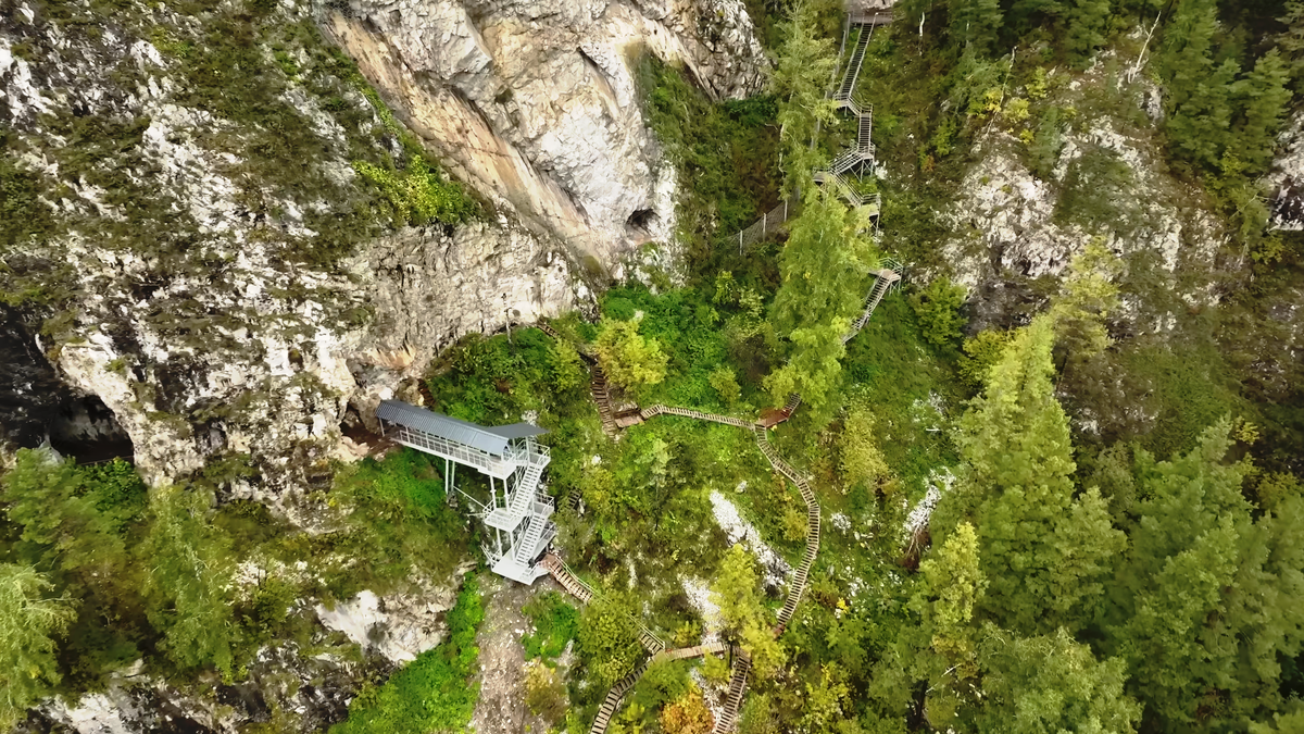 «Вход в Большую Тавдинскую пещеру оборудован удобными деревянными лестницами и смотровыми площадками. Этот массив включает около 30 пещер, расположенных на левом берегу реки Катунь в районе туристического комплекса "Бирюзовая Катунь"».