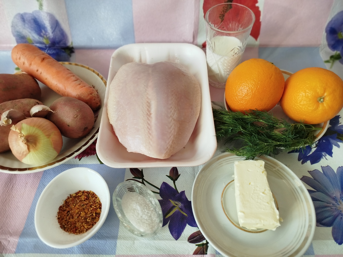Для приготовления этого блюда потребуется: куриная грудка, 3 большие картофелины, одна морковка, 1 луковица, 2 апельсина, масло 100 гр, молоко 100 мл, специи для курицы столовая ложка, соль по вкусу, укроп.