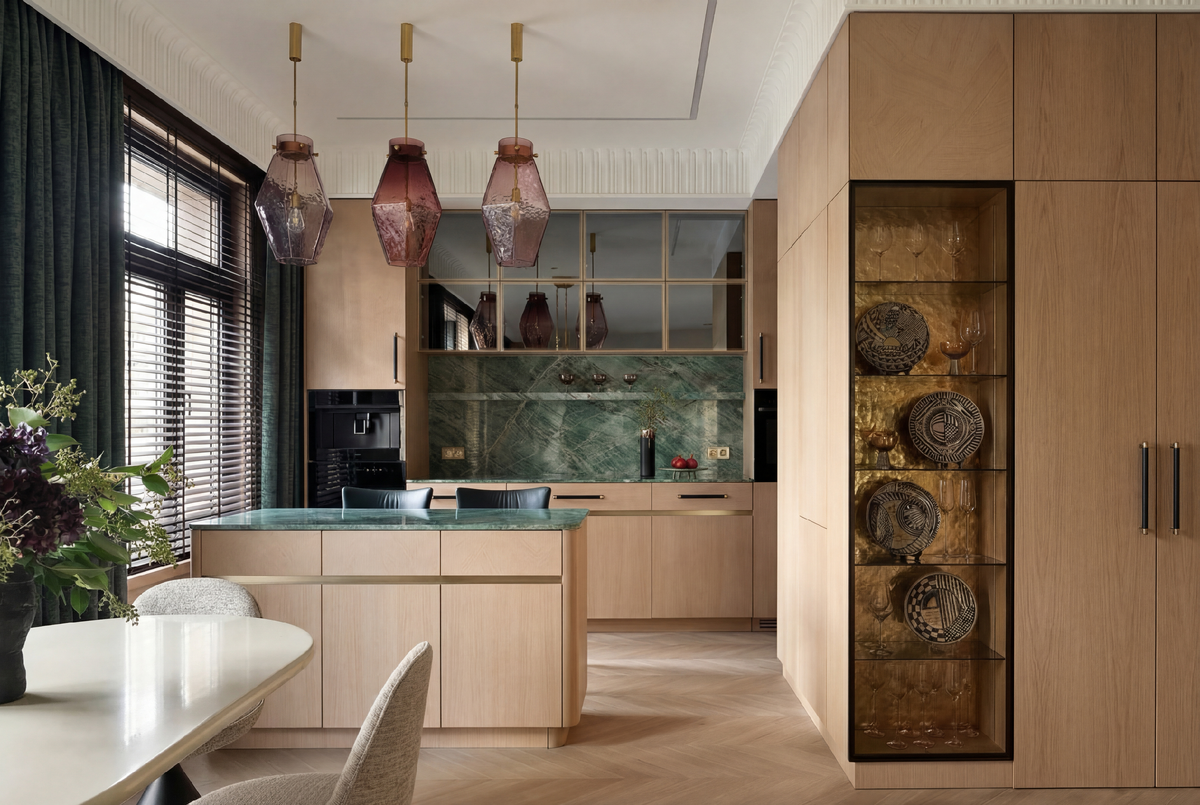 Светлая кухня с зелёным камнем, стеклянной витриной для посуды и островом с дополнительным хранением. 