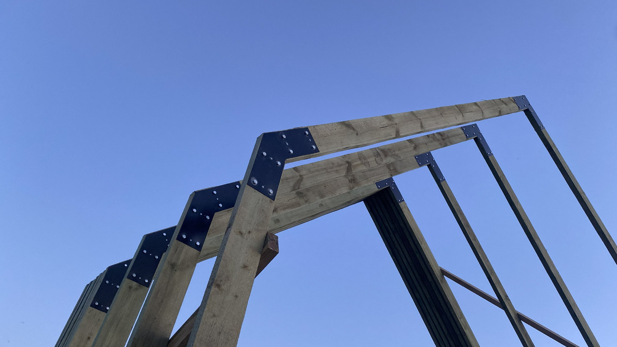 Здесь отлично виден сам узел. Черная сталь, мощные болты и то, как плотно коннектор обхватывает доску.