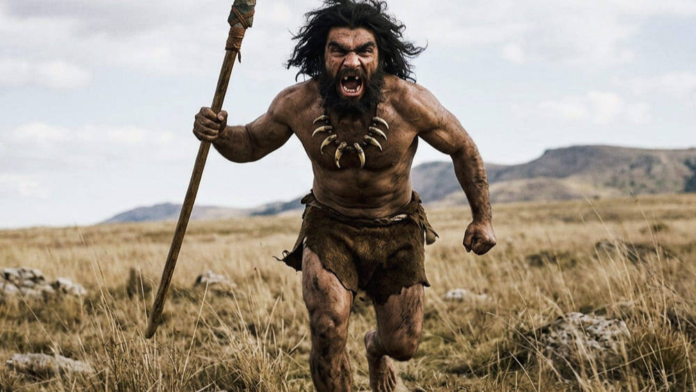 На фотографии изображен первобытный мужчина с копьем в руке, бегущий по открытой равнине в одежде из шкур, с ожерельем из зубов и с открытым ртом. Изображение сгенерировано в ИИ для иллюстрации идеи.