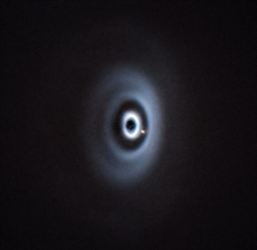 На этой фотографии недели от 26 августа 2025 года, опубликованной Европейской южной обсерваторией, изображена экзопланета WISPIT 2b в процессе формирования в протопланетном диске вокруг звезды WISPIT 2. По словам представителей ESO, это «первое чёткое обнаружение молодой планеты в диске с несколькими кольцами». Астрономы считают, что промежутки в диске образуются из-за того, что молодые планеты поглощают вещество из диска. Источник: ESO