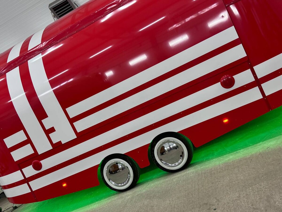 Красный фудтрак от РЕТРОТРАК с белыми полосами Шелби на кузове с включенной зеленой подсветкой днища