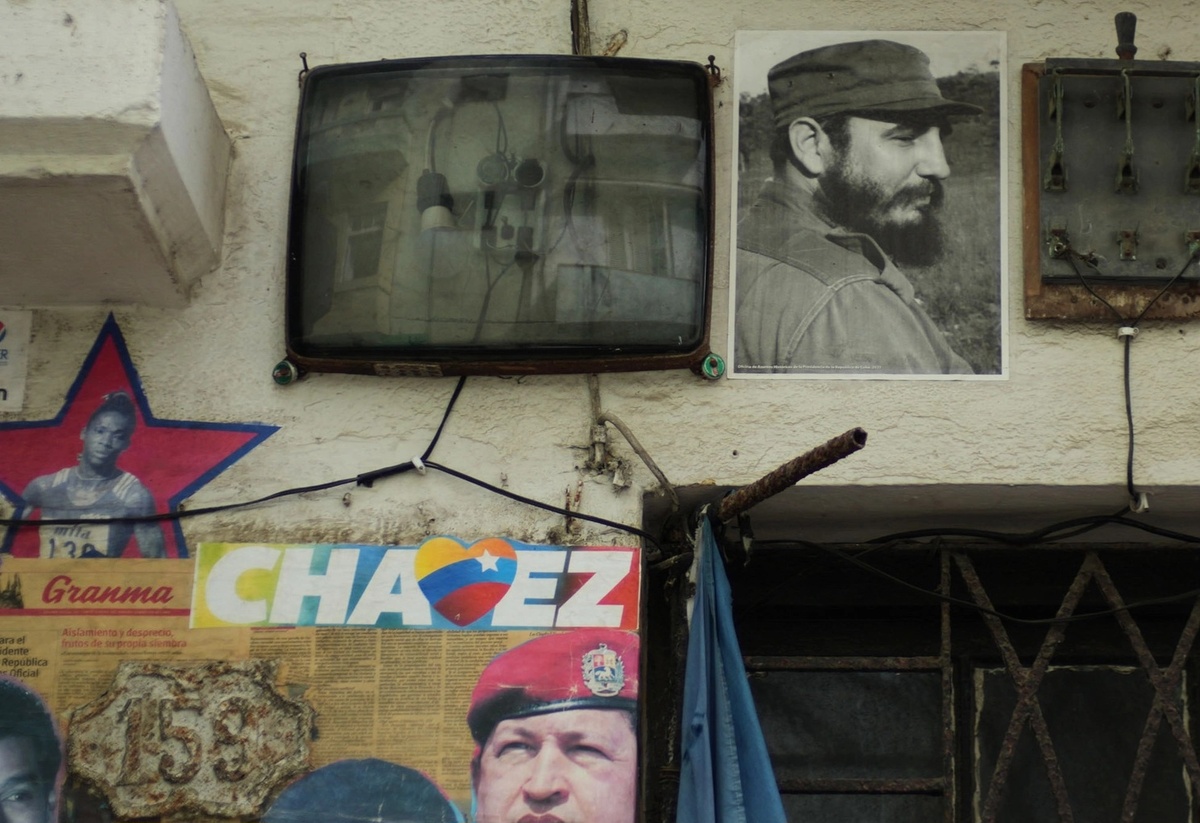 Портреты покойных Фиделя Кастро и Уго Чавеса висят у здания рядом с электрическими проводами во время блэкаута в Гаване, вторник, 17 марта 2026 года. | Рамон Эспиноса/AP.