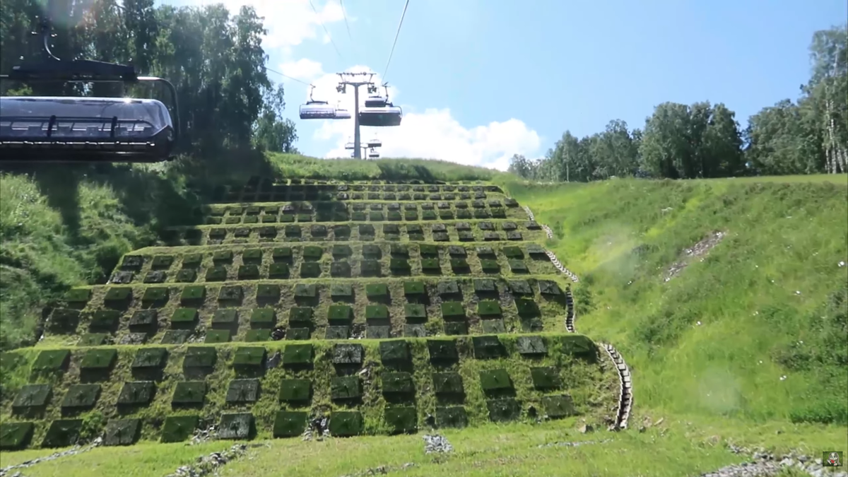 Масштабы поражают: подъем на гору Малая Синюха в современных восьмиместных кабинах. Обратите внимание на инженерные решения для укрепления склона — те самые «зеленые ступени», которые защищают гору от эрозии.