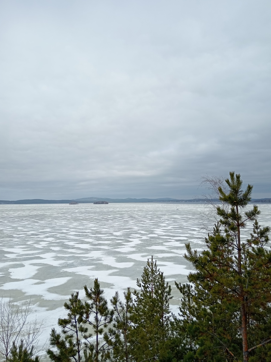 Вид на Среднеуральское водохранилище с обрывистого берега. Там вдали мелкие черные точечки - это безумцы вышли на рыбалку по последнему льду 