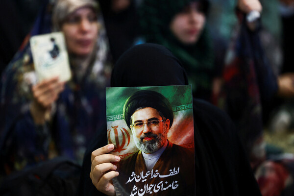 Портрет Моджтабы Хаменеи в руках женщины во время молитвы, март 2026 года / Majid Asgaripour/WANA (West Asia News Agency) via Reuters   📷