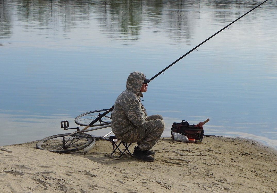 Рыболов сосредоточен на поплавке. Ждет поклёвки ...
