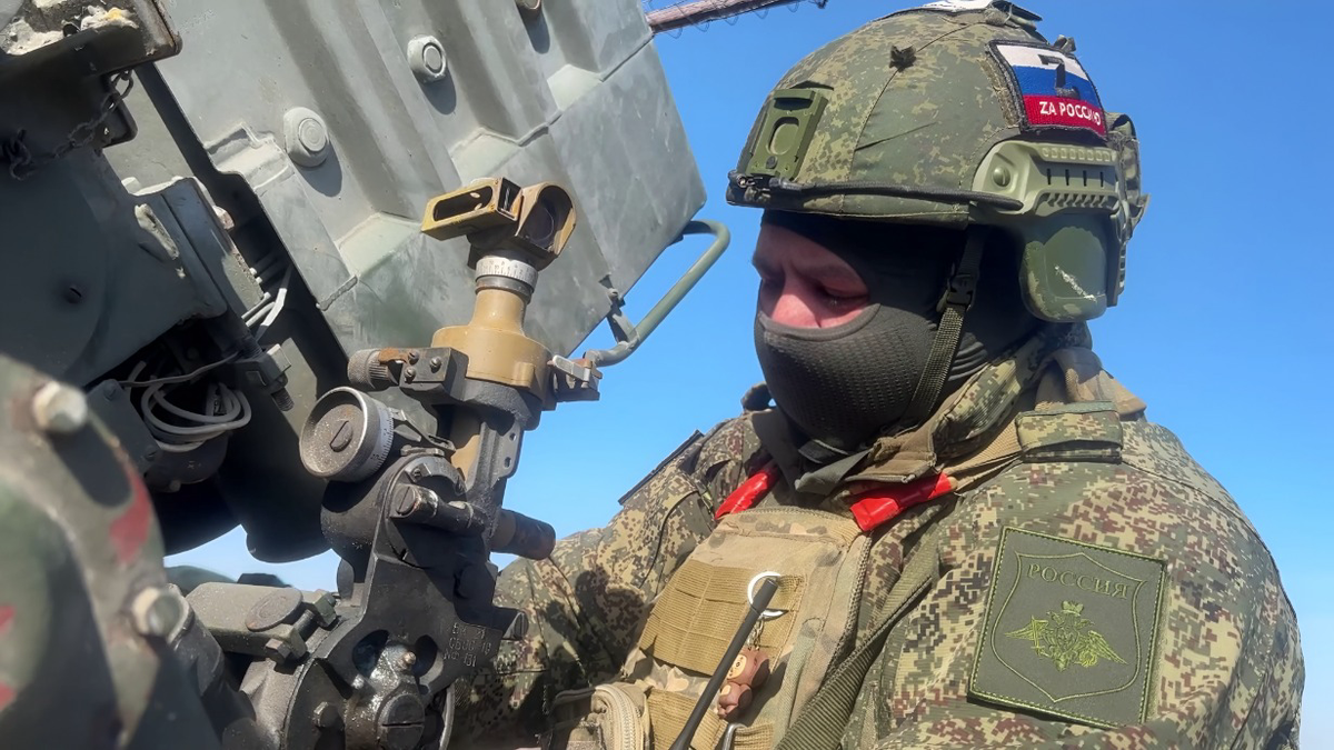    Наводчик реактивной системы залпового огня «Град» наводит орудие по буссоли для поражения цели / Фото: Марат Чернышов